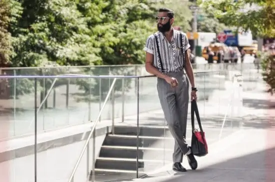 Hippe man draagt een klassieke grijze broek, een hemd met geometrische patronen en bretels - 10 leuke street style blogs voor modeliefhebbers