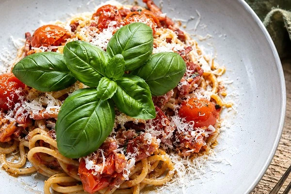 Snelle tomatenpasta met krokant spek, rode pesto en basilicum - AGMJ Recept
